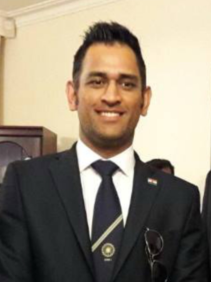 MS Dhoni smiling in a suit, photographed in 2016