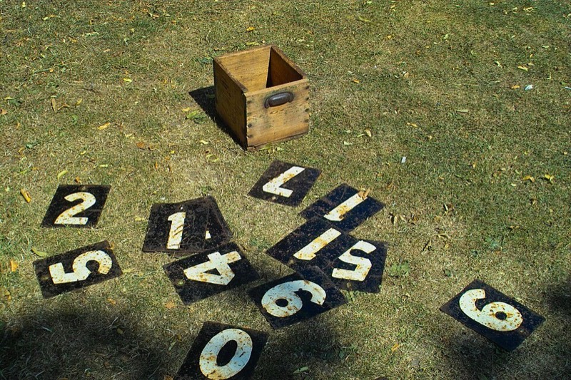 Number plates for a traditional cricket scoreboard arranged on the grass