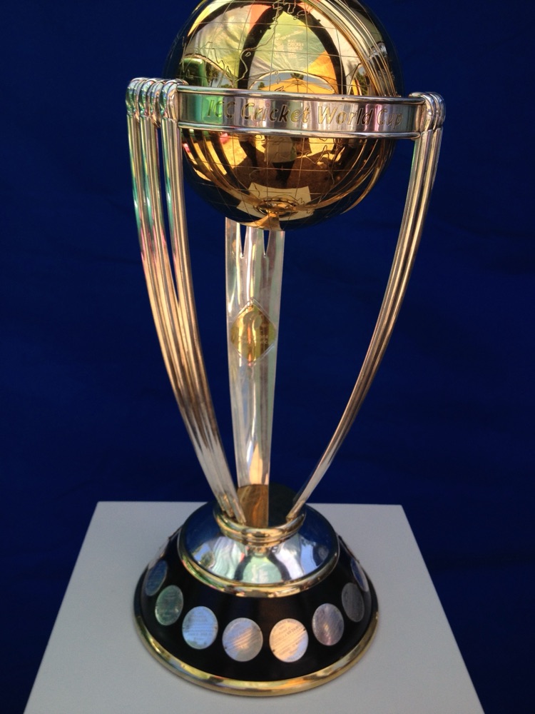 Gold and silver ICC Cricket World Cup trophy against a deep blue background