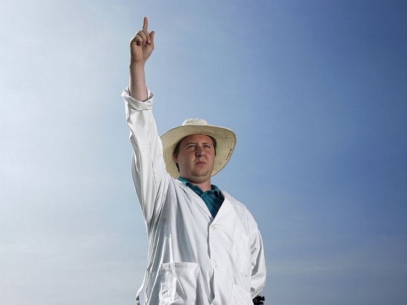 Cricket umpire raising a finger to signal a dismissal