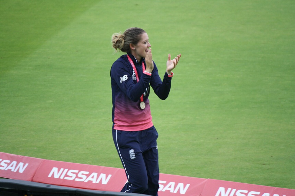 England cricketer wearing her winner's medal and applauding after the 2017 Women's Cricket World Cup final